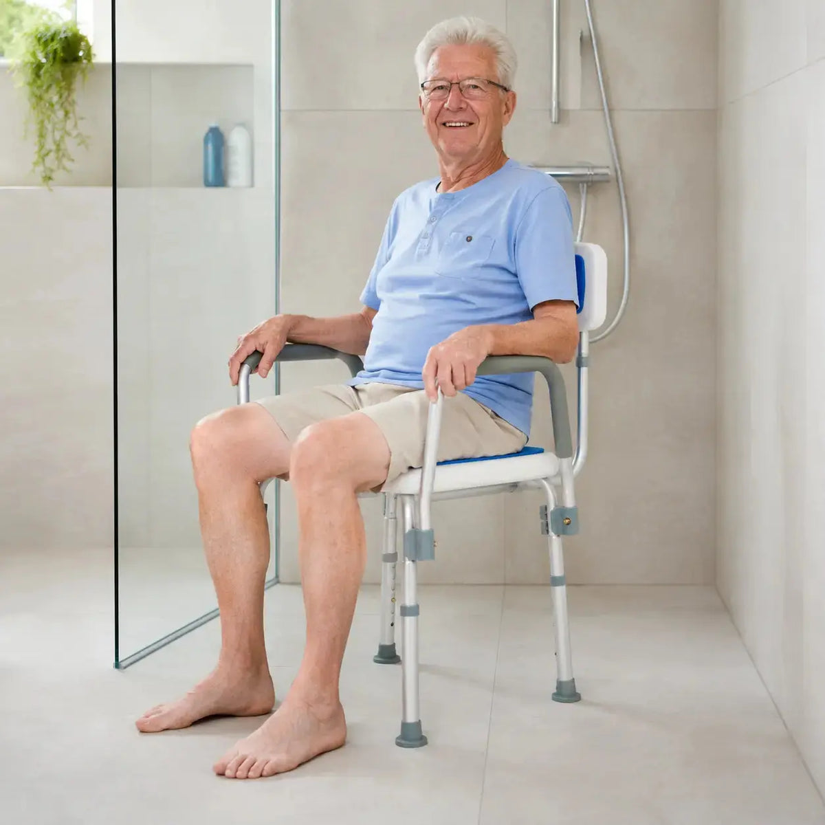 Henk zit veilig en comfortabel op een douchestoel in zijn badkamer.